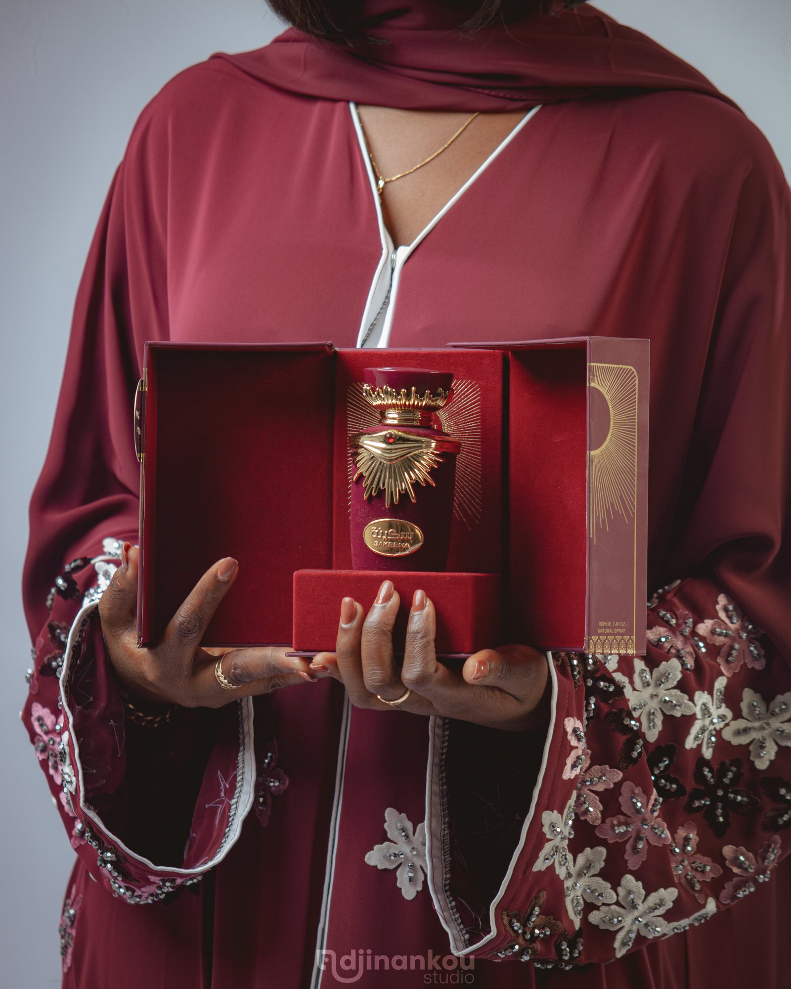 A hand holding a perfume bottle